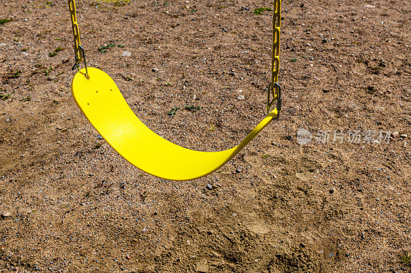 empty yellow swing on a playground